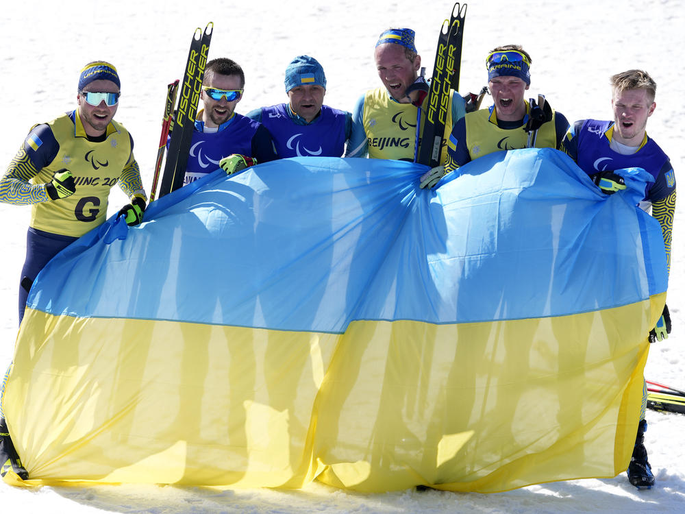 Guide Oleksandr Mukshyn, Anatolii Kovalevskyi, Vitalii Lukianenko, guide Borys Babar, guide Oleksandr Nikonovych and Dmytro Suiarko celebrate their sweep in the men's middle distance vision impaired para biathlon at the 2022 Winter Paralympics on Tuesday in China.