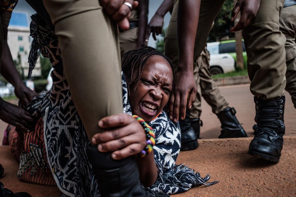 Stella Nyanzi, center, a prominent Ugandan activist and government critic, is arrested by police officers as she organised a protest for more food distribution by the government to people who has been financially struggling by the nationwide lockdown imposed to curb the spread of the COVID-19 coronavirus in Kampala, on May 18, 2020.