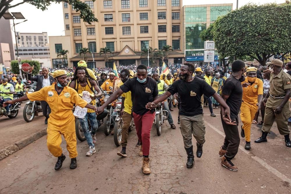 Supporters of the National Resistance Movement (NRM) parade as they wait for the arrival of the re-elected Ugandan President Yoweri Museveni on his way back from his country home in Kampala, on Jan. 21, 2021.