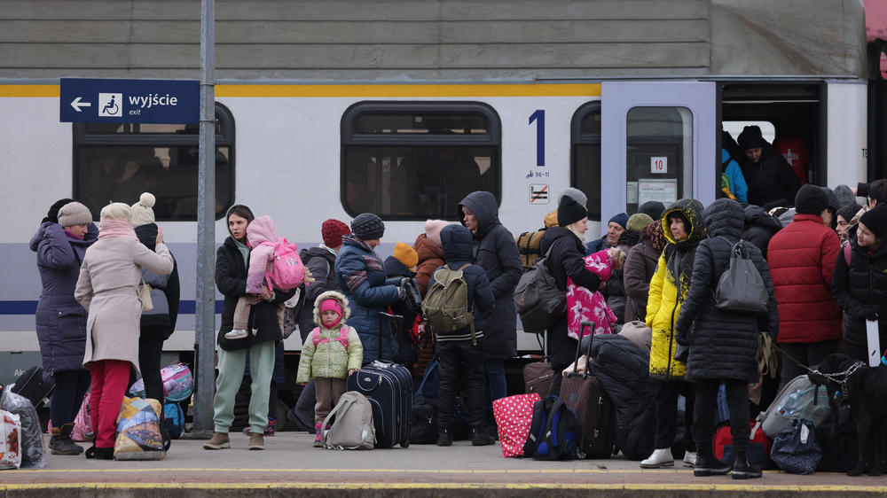 People arriving from Ukraine wait at the main railway station for a train to take them to Warsaw on Monday in Przemysl, Poland.