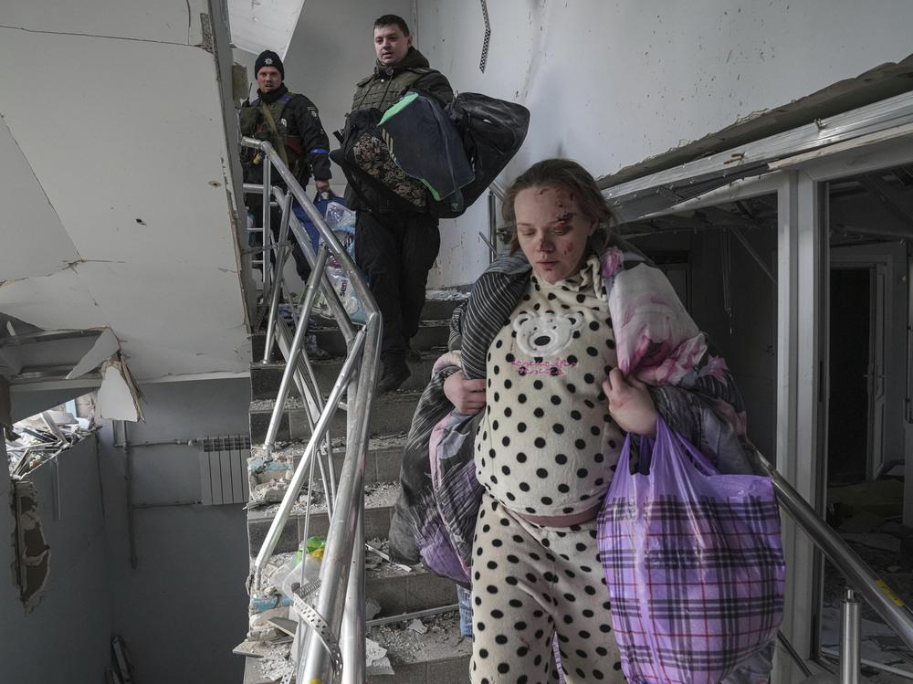 An injured pregnant woman walks down stairs in a maternity hospital in Mariupol, Ukraine, on Wednesday. The hospital was hit hard by a Russian attack on the besieged port city, Ukrainian officials say.