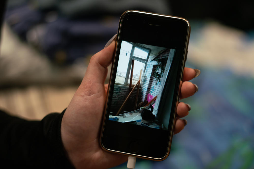 Katerina Beliakova, 21, shows a photo she says she received from her father of her parents' home in the besieged coastal city of Mariupol, Ukraine.