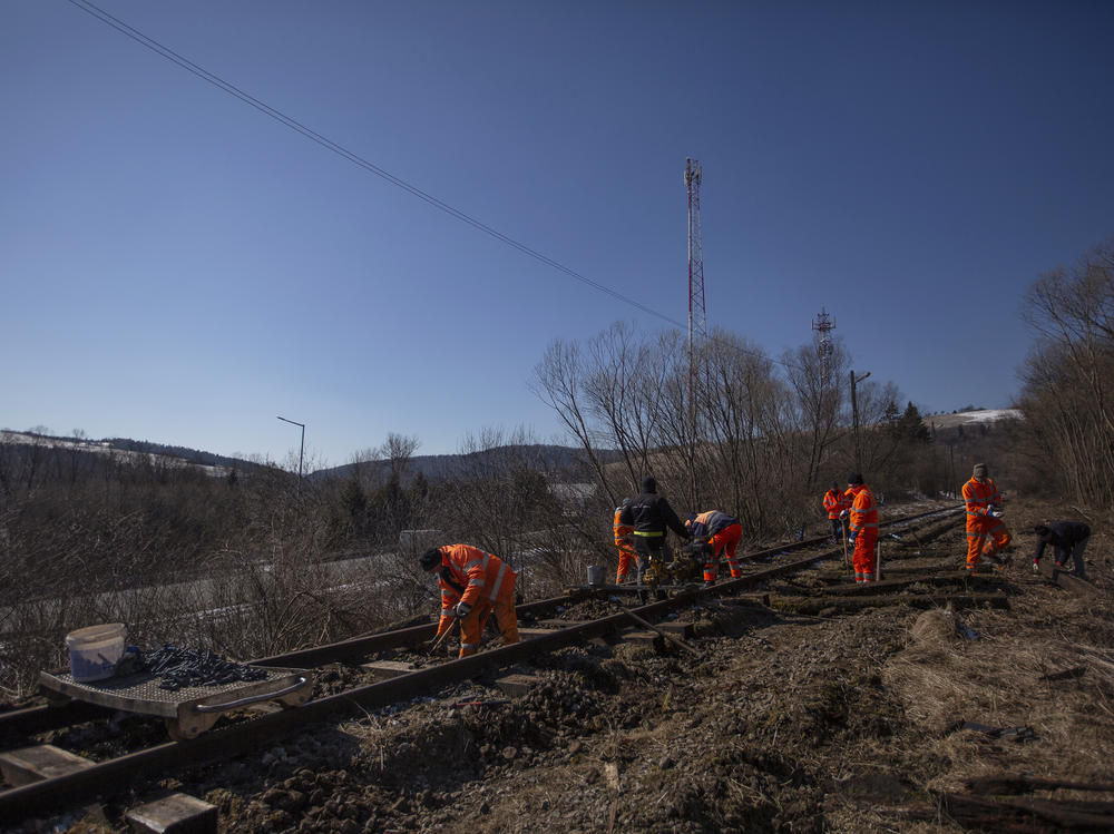 A crew of men repair an abandoned rail line that once connected this rural part of southern Poland to Ukraine.