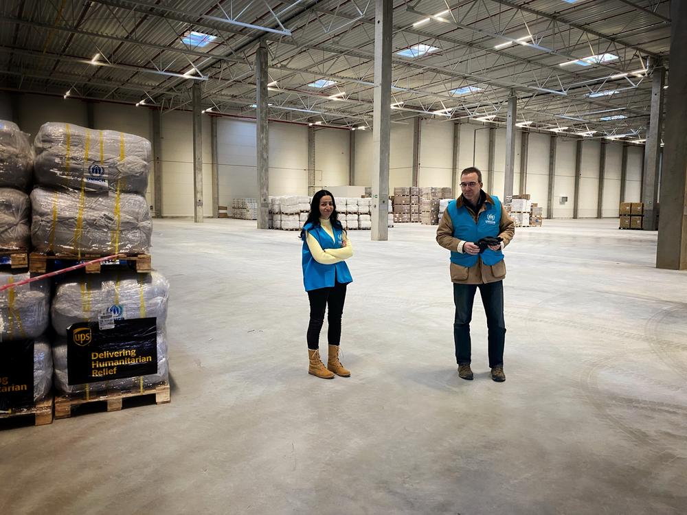 Alkebeh and UNHCR's Chris Melzer survey the enormous warehouse where supplies are being sorted.