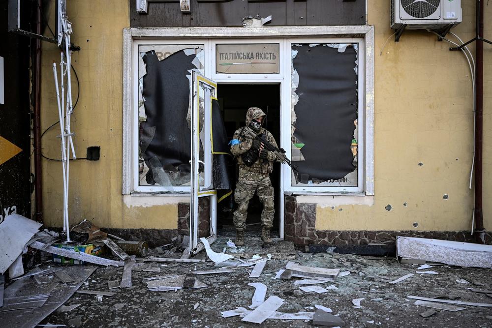 <strong>March 12: </strong>A Ukrainian serviceman exits a damaged building after shelling in Kyiv.