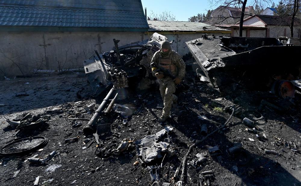 <strong>March 12:</strong> A Ukrainian soldier examines a destroyed Russian armoured personal carrier (APC) in Irpin, north of Kyiv.