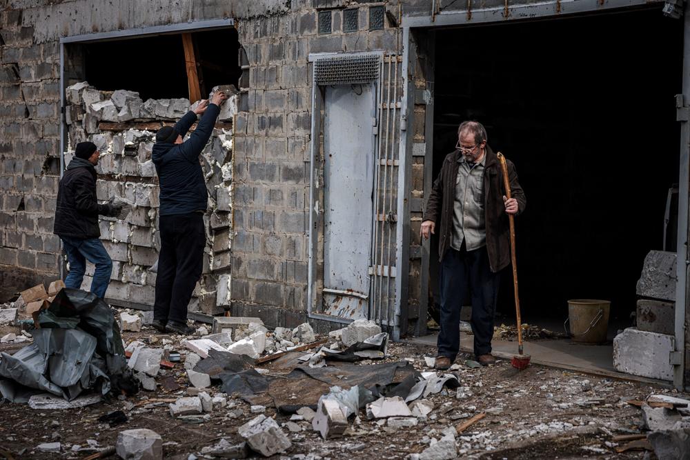 <strong>March 12: </strong>Residents try to strengthen the wall of a house damaged by recent shelling, on the outskirts Kyiv.