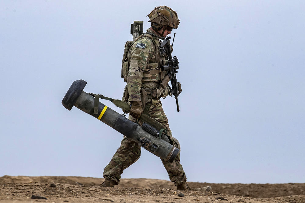 A U.S. soldier walks with a Javelin missile launcher in the countryside of Deir Ezzor in northeastern Syria in December of 2021.