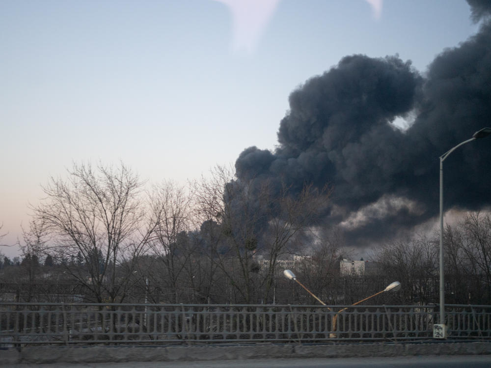 Smoke billows over a street near the airport in Lviv after Russian airstrikes hit a jet repair facility.