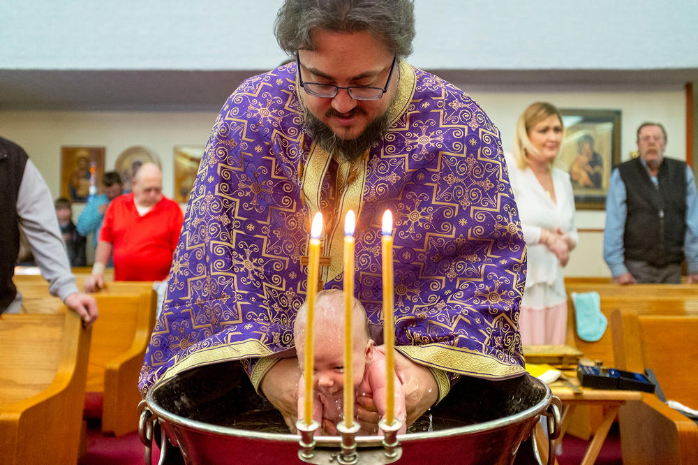 <strong>March 13:</strong> The Rev. Stephen Osburn baptizes baby Rowelin inside St. Mary's Holy Dormition Orthodox Church in Simla, Colorado.