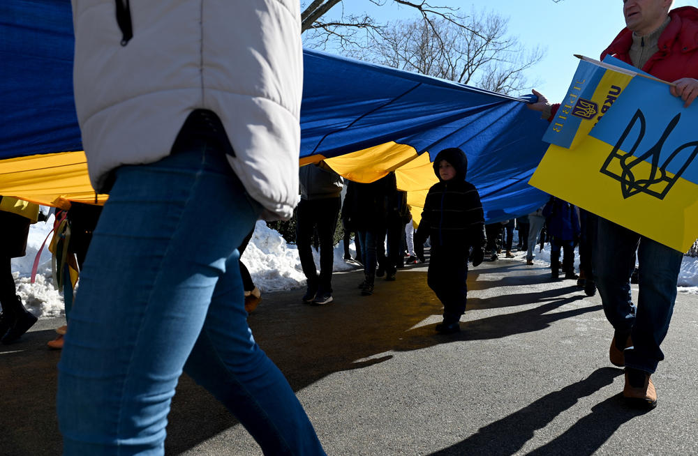 <strong>Feb. 27:</strong> Marko, a young boy who is originally from Ukraine but now lives in Harvard, Massachusetts, walks under a large flag being carried during a rally in support of Ukraine on the Boston Common.