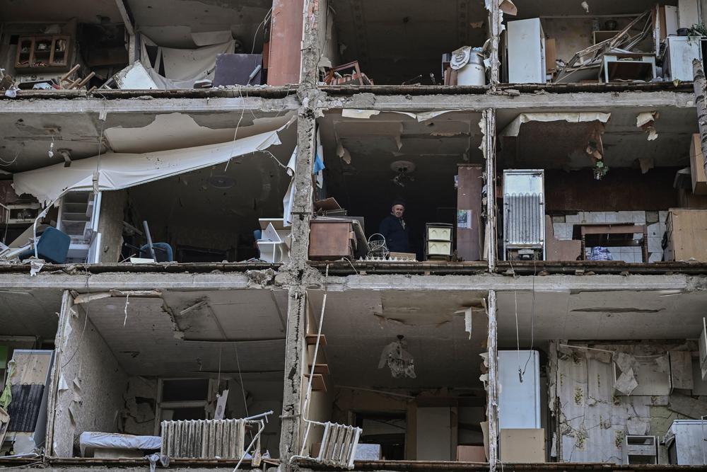 <strong>March 25:</strong> A man stands inside an apartment building destroyed by shelling in Kharkiv, Ukraine.