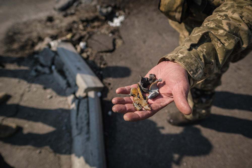 <strong>March 25:</strong> A member of territorial defense units shows the camera the pieces of shrapnel from a missile on the outskirts of the city of Kyiv, Ukraine.