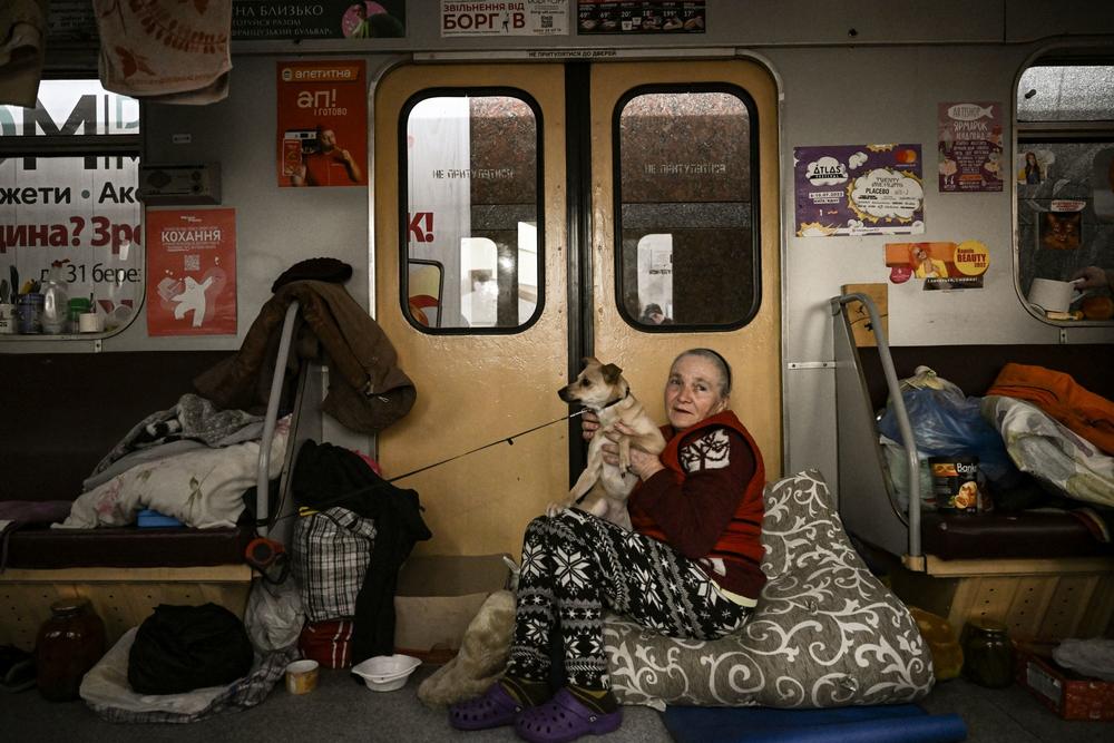 <strong>March 26:</strong> A woman holds a dog in a train at metro station used as a bomb shelter where people are living in Kharkiv.