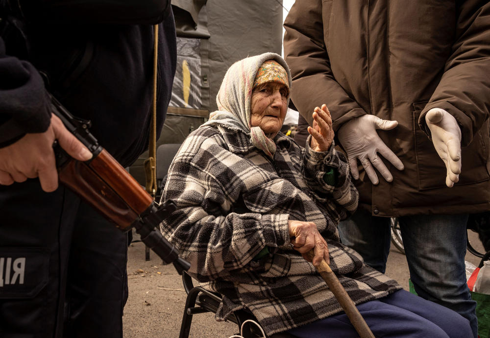 <strong>March 26</strong>: A woman reacts as she is assisted by police after fleeing her home in the suburbs of Kyiv.