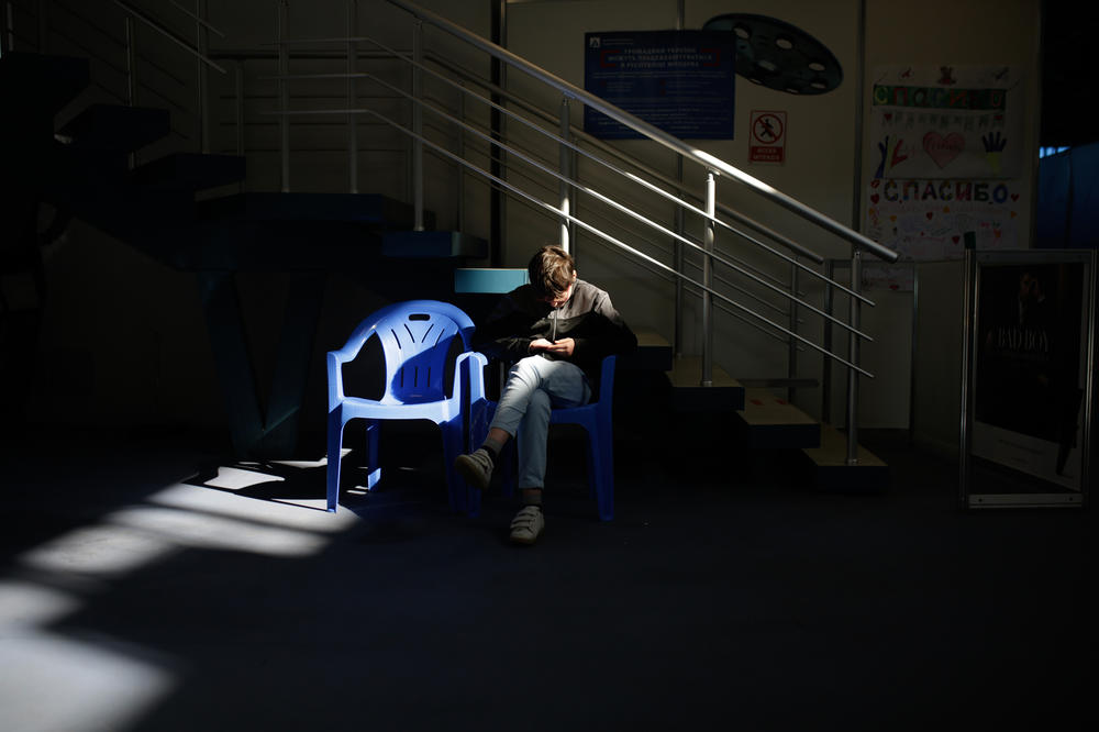 <strong>March 26:</strong> A boy sits in a chair at the pavilion converted into a refugee shelter in the center of Moldexpo in Chisinau, Moldova.
