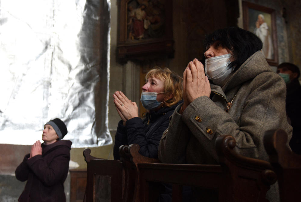 <strong>March 27</strong>: Worshippers pray during a Sunday mass at Saints Peter and Paul Garrison Catholic Church in Lviv.