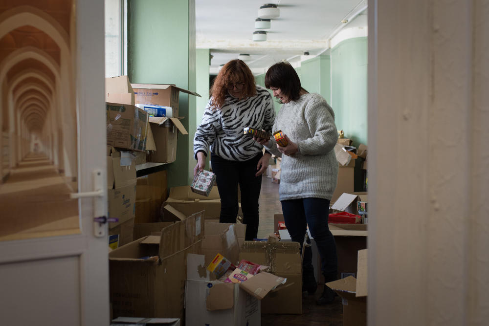 Volunteers at a youth center pack boxes of groceries and toiletries for Ukrainians displaced by the war.