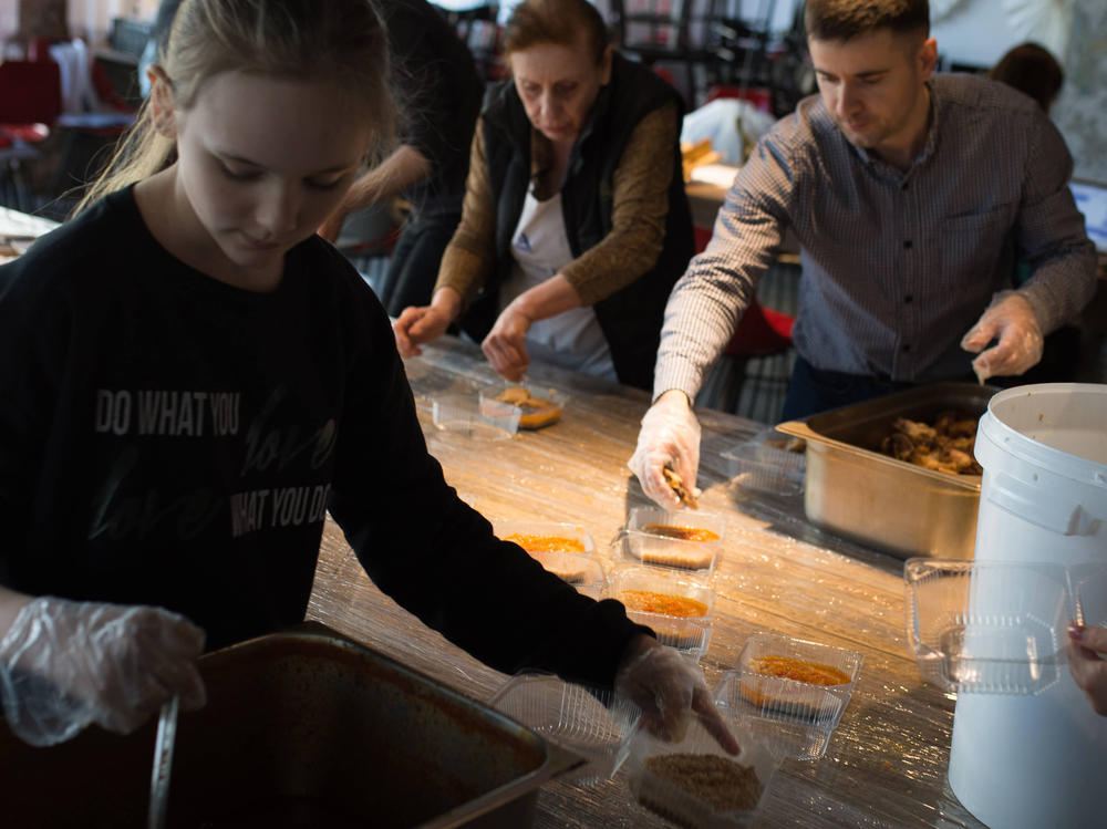 Volunteers, many of them forced to flee the war in other parts of Ukraine, pack meals for members of the country's Territorial Defense Forces in Moderna restaurant in Dnipro, Ukraine.