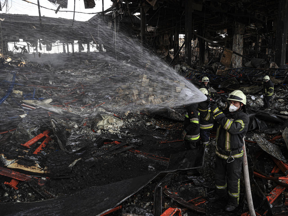Firefighters continue working on Tuesday to cool down a destroyed logistics warehouse where thousands of tons of food became unusable after Russian shelling hit the facility on March 13 in Kyiv, Ukraine.