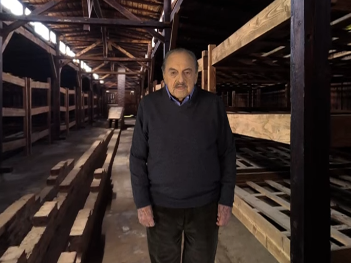 Standing in front of a green screen, survivor George Brent recounts his experience at Auschwitz-Birkenau in the VR film 