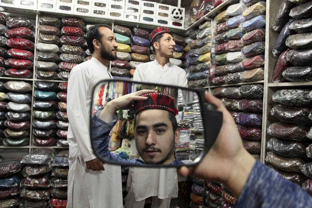 <strong>Peshawar, Pakistan:</strong> A man tries on a traditional cap in preparation for Ramadan.