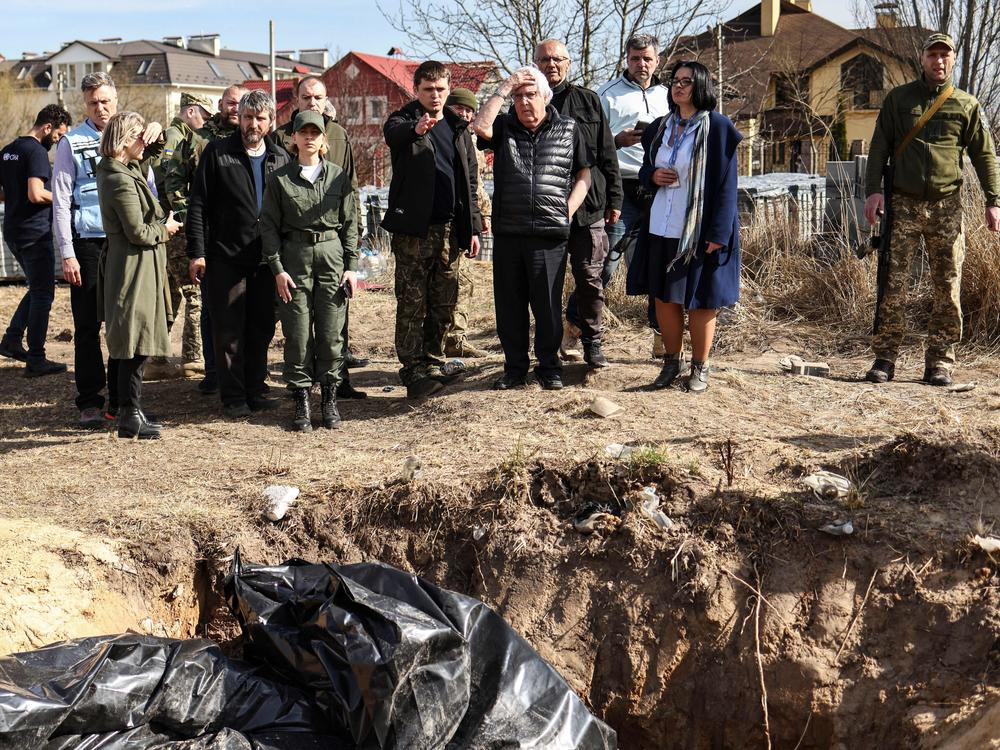 U.N. humanitarian chief Martin Griffiths puts his hand on his head as he reacts to the sight of a mass grave Ukrainians dug near a church in Bucha, on April 7. Griffiths said investigators will probe civilian deaths uncovered after Russian troops withdrew.
