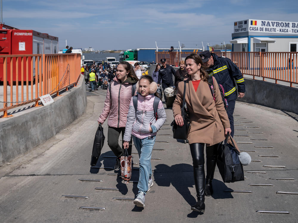 Ukrainian refugees get off the ferry after crossing the Danube into Romania in Isaccea on Friday.