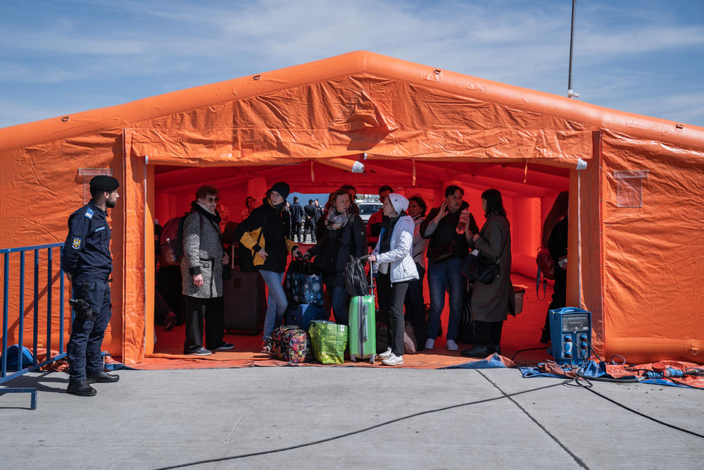 Ukrainian refugees gather in the triage tents set up at the border in Isaccea, Romania, on Friday. It's where refugees wait until going to have their documents checked.