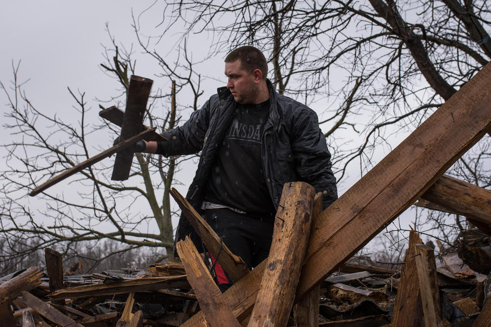 Ivan Mekshun, resident of a village just outside of Chernihiv, digs through the debris of his destroyed home.