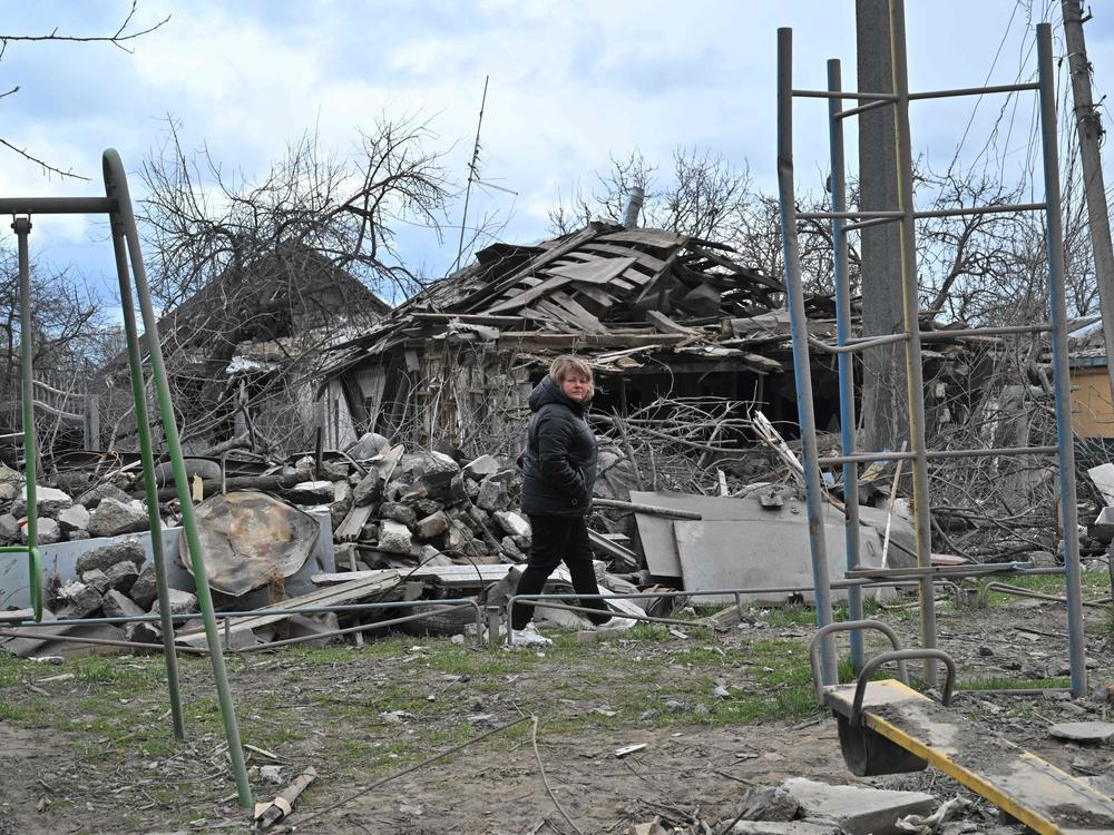 A woman walks past a destroyed house following bombardment in the Ukrainian town of Borodianka, in the Kyiv region, on Sunday.