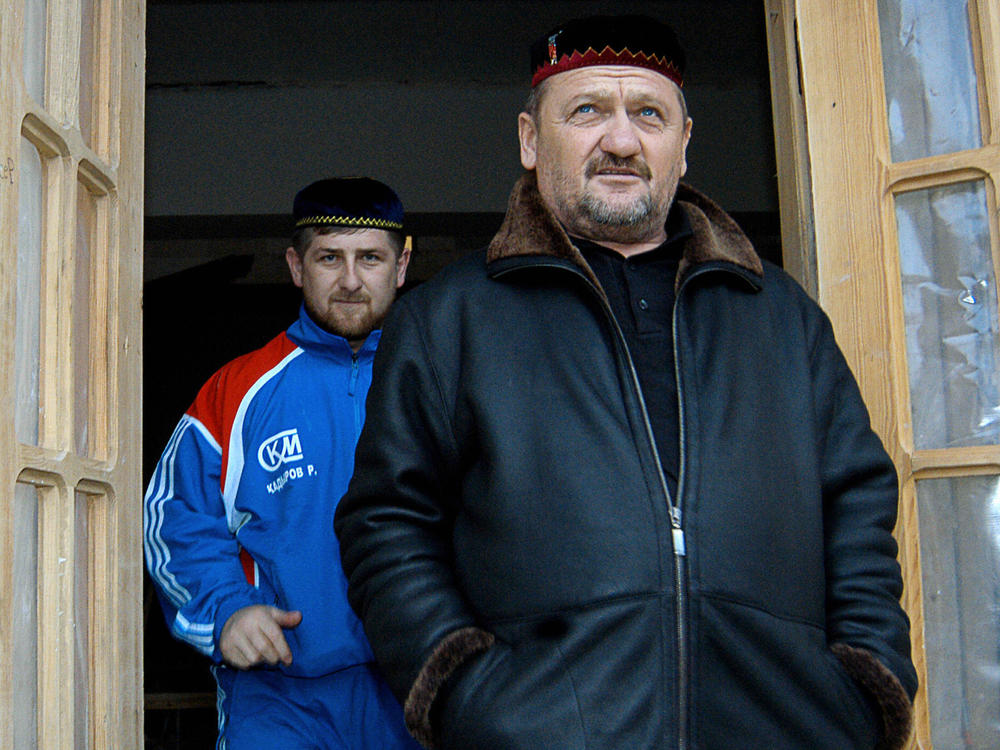 Former Chechen President Akhmad Kadyrov (R) and his son Ramzan standing in front of Ramzan's house in January 2004.