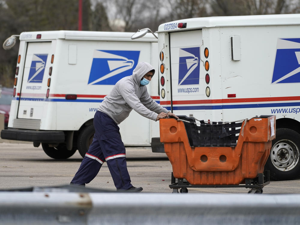 A U.S. Postal Service employee works outside a post office in Wheeling, Ill., on Dec. 3, 2021.