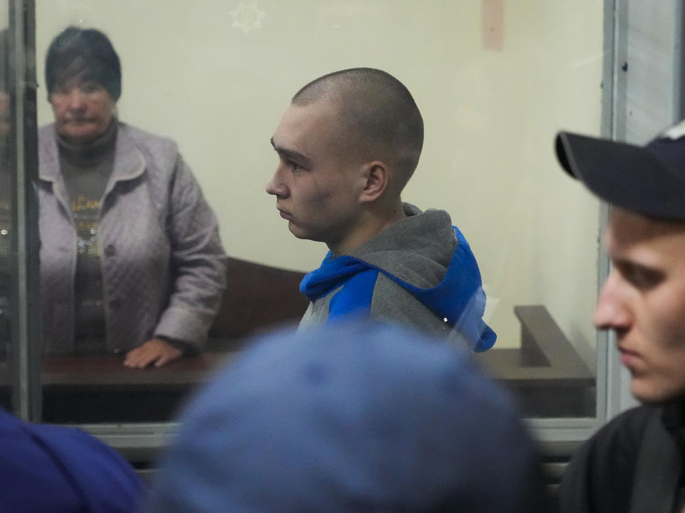 Russian army Sgt. Vadim Shishimarin, 21, is seen behind glass during a court hearing in Kyiv on Wednesday. He went on trial in Ukraine for the killing of an unarmed civilian and pleaded guilty. It is the first time a member of the Russian military has been prosecuted for a war crime since Russia invaded Ukraine in February.