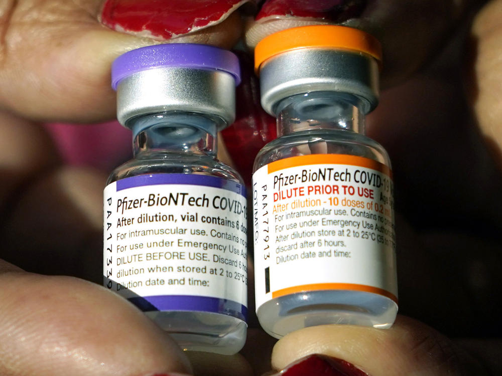 A nurse holds a vial of the Pfizer COVID-19 vaccine for children ages 5 to 11, right, and a vial of the vaccine for adults, which has a different colored label, at a vaccination station in Jackson, Miss., on Feb. 8.