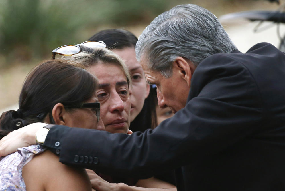 The Archbishop of San Antonio, Gustavo Garcia Seller, comforts families outside of the Civic Center.