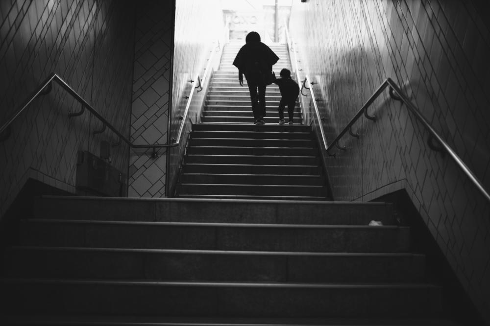 Seoul, Korea - Nov. 1, 2019: A woman and child ascend the staircase of a subway exit.
