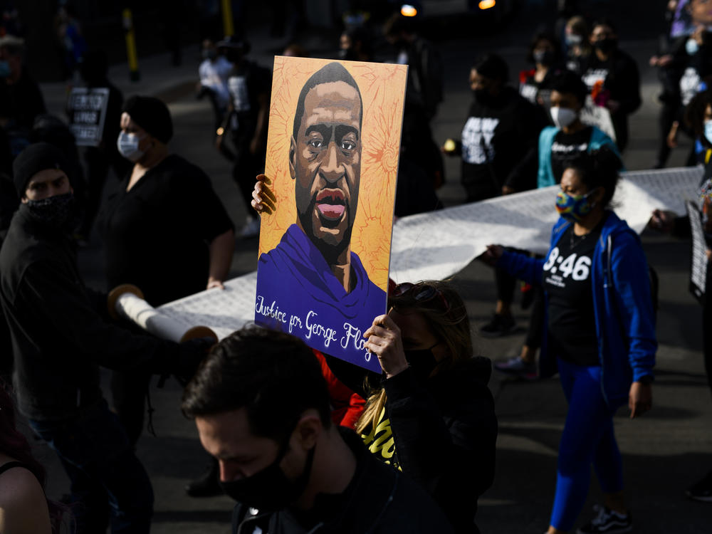 Demonstrators carry a scroll listing the names of people killed by police during a march in honor of George Floyd on March 7, 2021 in Minneapolis, Minnesota.