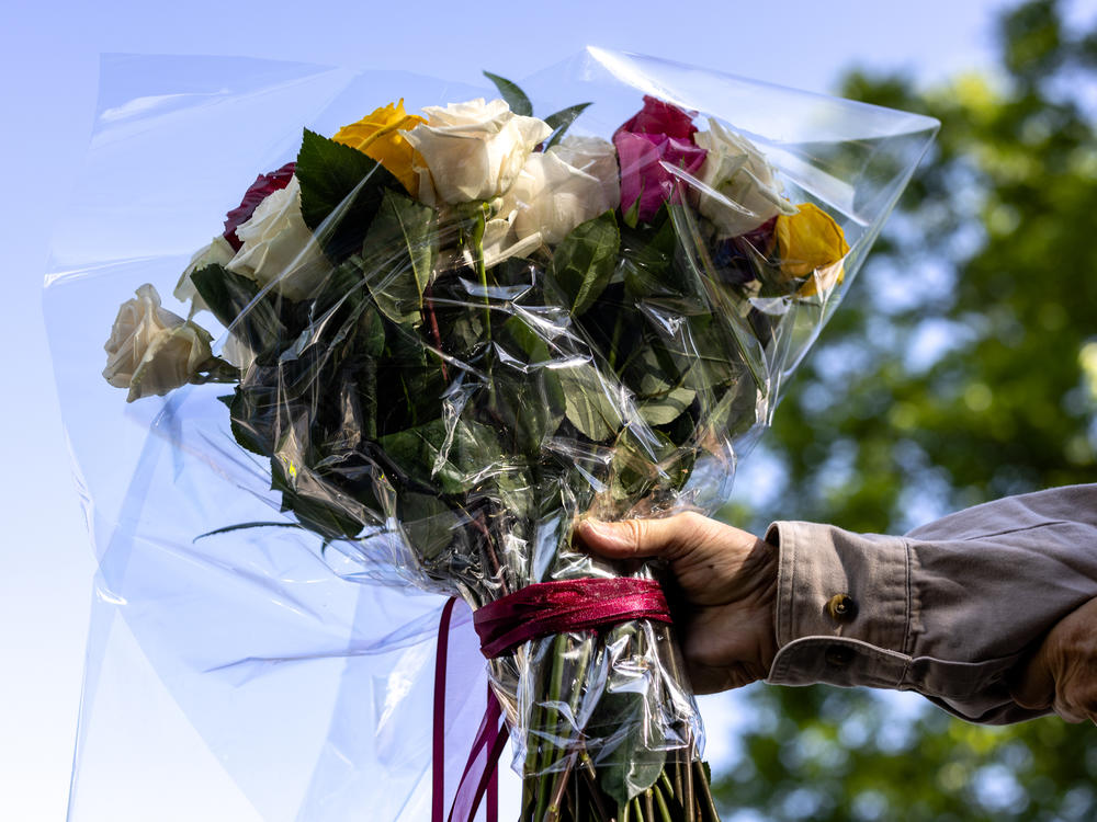 A man brings flowers to Robb Elementary School on Wednesday in Uvalde, Texas.