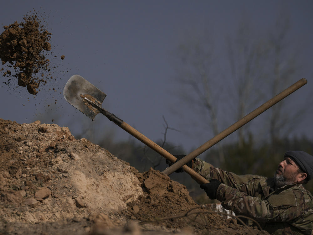 A Ukrainian serviceman digs a trench outside the capital Kyiv in March. Facing a more powerful Russian army, the Ukrainians have had to figure out ways to defend themselves. The Ukrainians have stressed basic measures, like digging deeper trenches to defend against Russian artillery, as well as high-tech methods, like using computer tablets on the battlefield to coordinate their artillery fire.