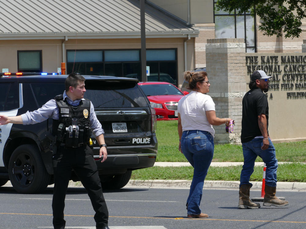 A law enforcement officer helps people cross the street at Uvalde Memorial Hospital after a shooting was reported earlier in the day at Robb Elementary School, Tuesday, May 24, 2022, in Uvalde, Texas.