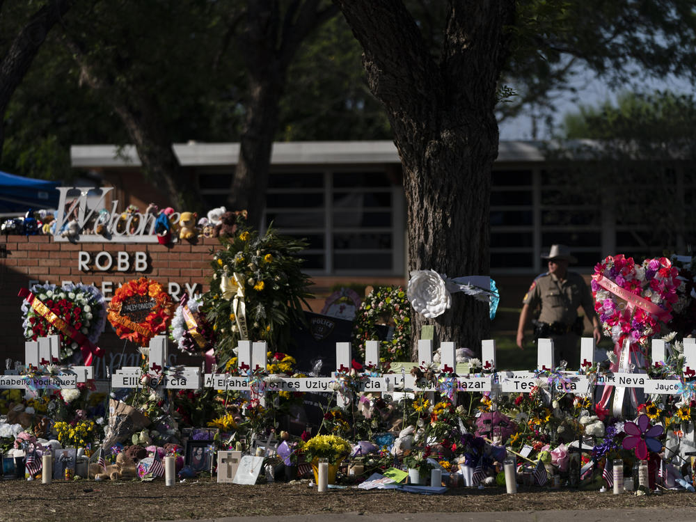 Flowers and candles are placed around crosses at a makeshift memorial outside Robb Elementary School to honor the victims killed in the shooting in Uvalde, Texas.