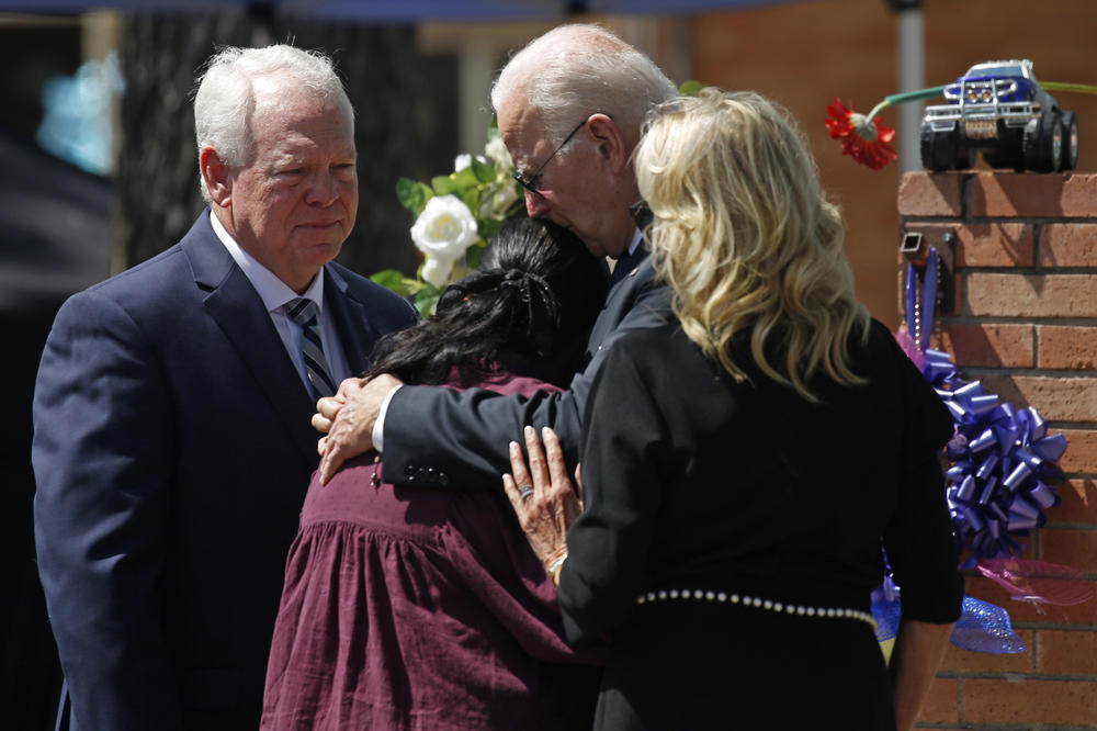 President Joe Biden and First Lady Jill Biden comfort Principal Mandy Gutierrez as Superintendent Hal Harrell stands next to them, at a memorial outside Robb Elementary School to honor the victims killed in a school shooting in Uvalde, Texas Sunday, May 29, 2022.