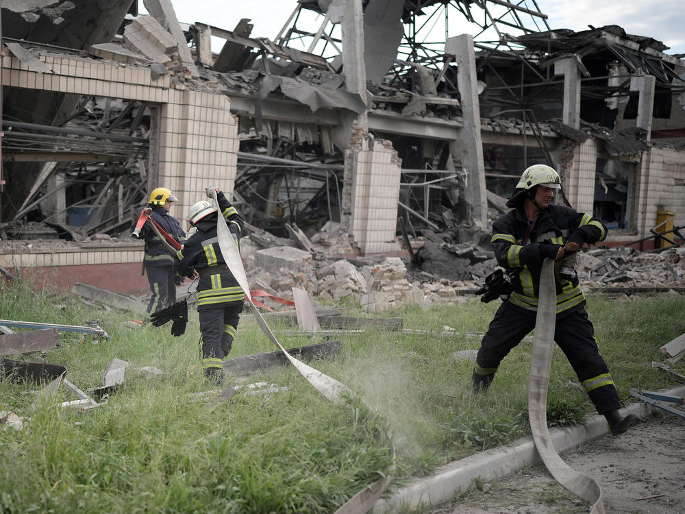 Firefighters continue to dampen a railcar repair facility in Kyiv after a Russian airstrike on Sunday.