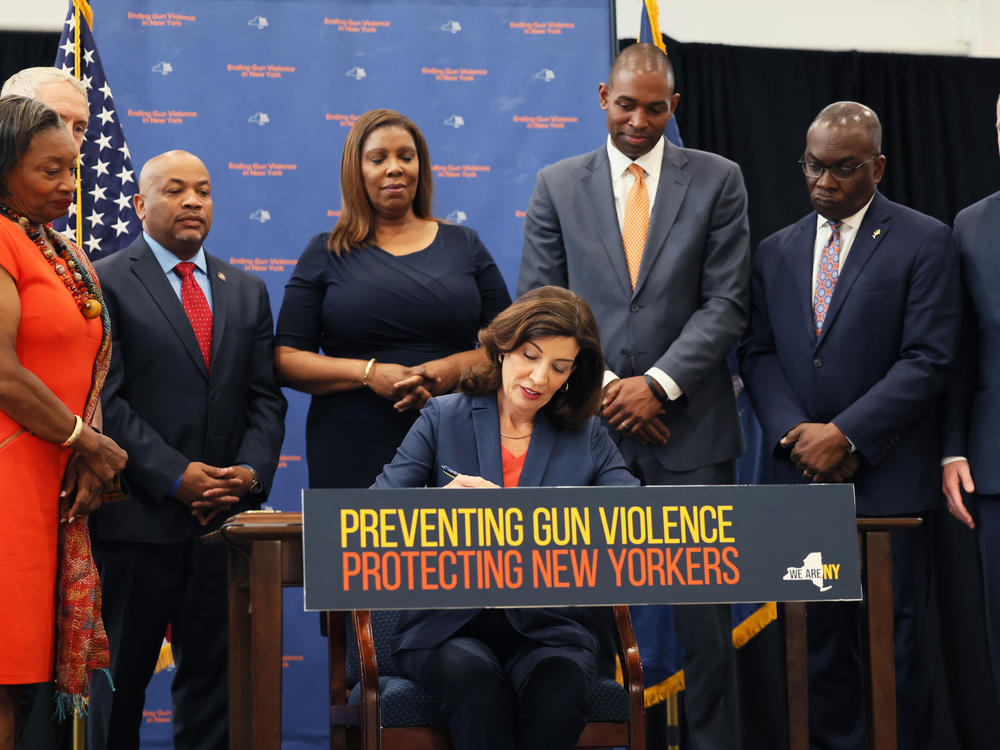 New York Gov. Kathy Hochul signs legislation limiting body armor access as she is surrounded by lawmakers during a bill-signing ceremony on June 6 in New York City.