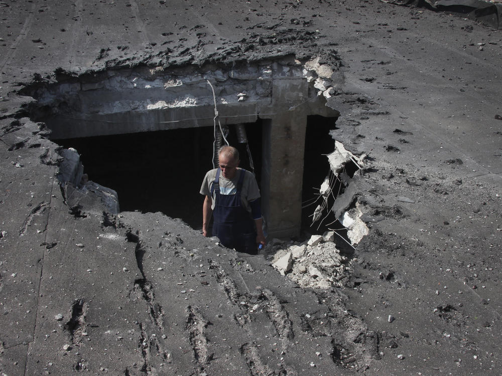 A man examines the roof of a hospital damaged during shelling in Donetsk, eastern Ukraine, on Tuesday.