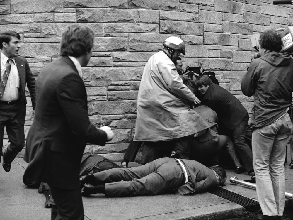 Secret Service agent Timothy J. McCarthy, foreground, Washington policeman Thomas Delahanty, center, and presidential press secretary James Brady, background, lie wounded on a street outside a Washington hotel after shots were fired at President Reagan on March 30, 1981.