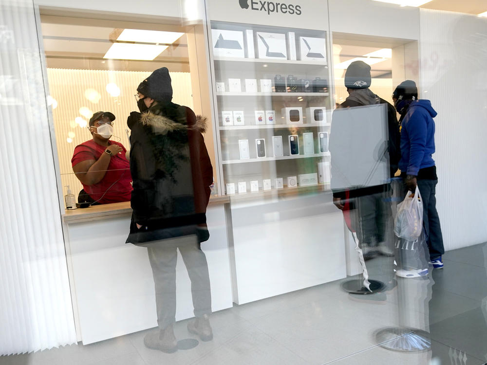 Customers pick up online orders at the Apple Store at the Towson Town Center in December 2020 in Towson, Md. Apple store employees in the Baltimore suburb voted to unionize by a nearly 2-to-1 margin on Saturday.