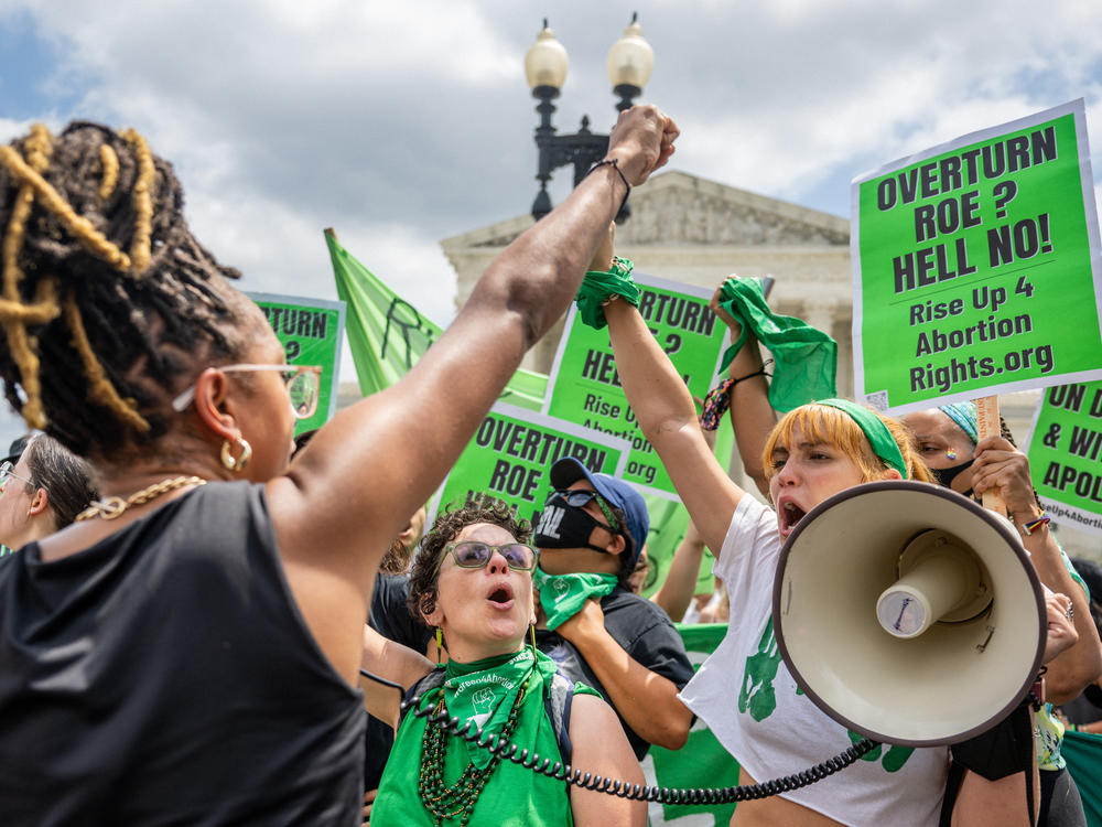 Abortion rights activists clad in green and carrying green signs protest outside the Supreme Court on Saturday.