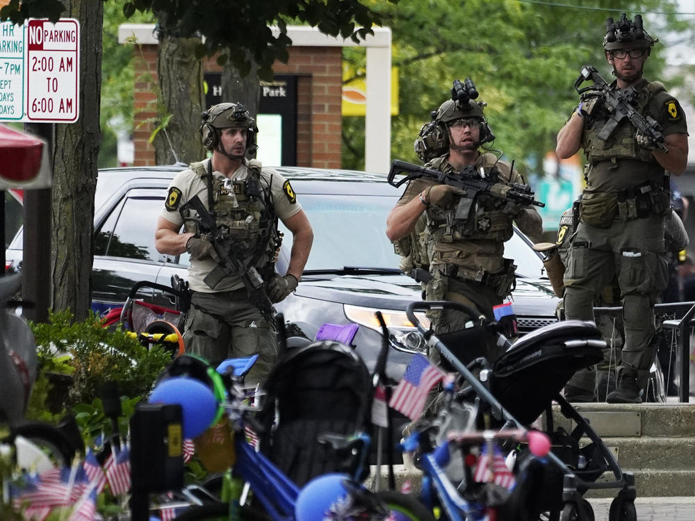 Law enforcement personnel secure the scene after a mass shooting Monday at a Fourth of July parade in downtown Highland Park, a Chicago suburb.